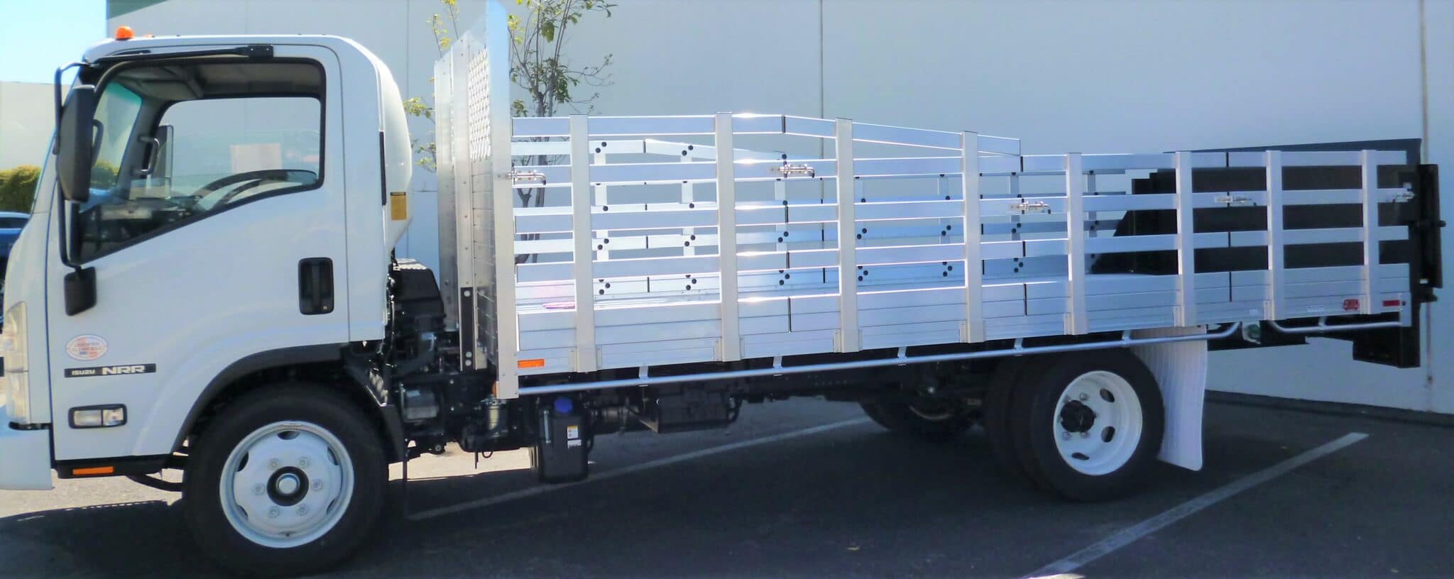 2014 Isuzu NPR 8'x16' aluminum stake bed 38" lift out front side stakes, 30" lift out side rear & a Tommy lift gate in the rear