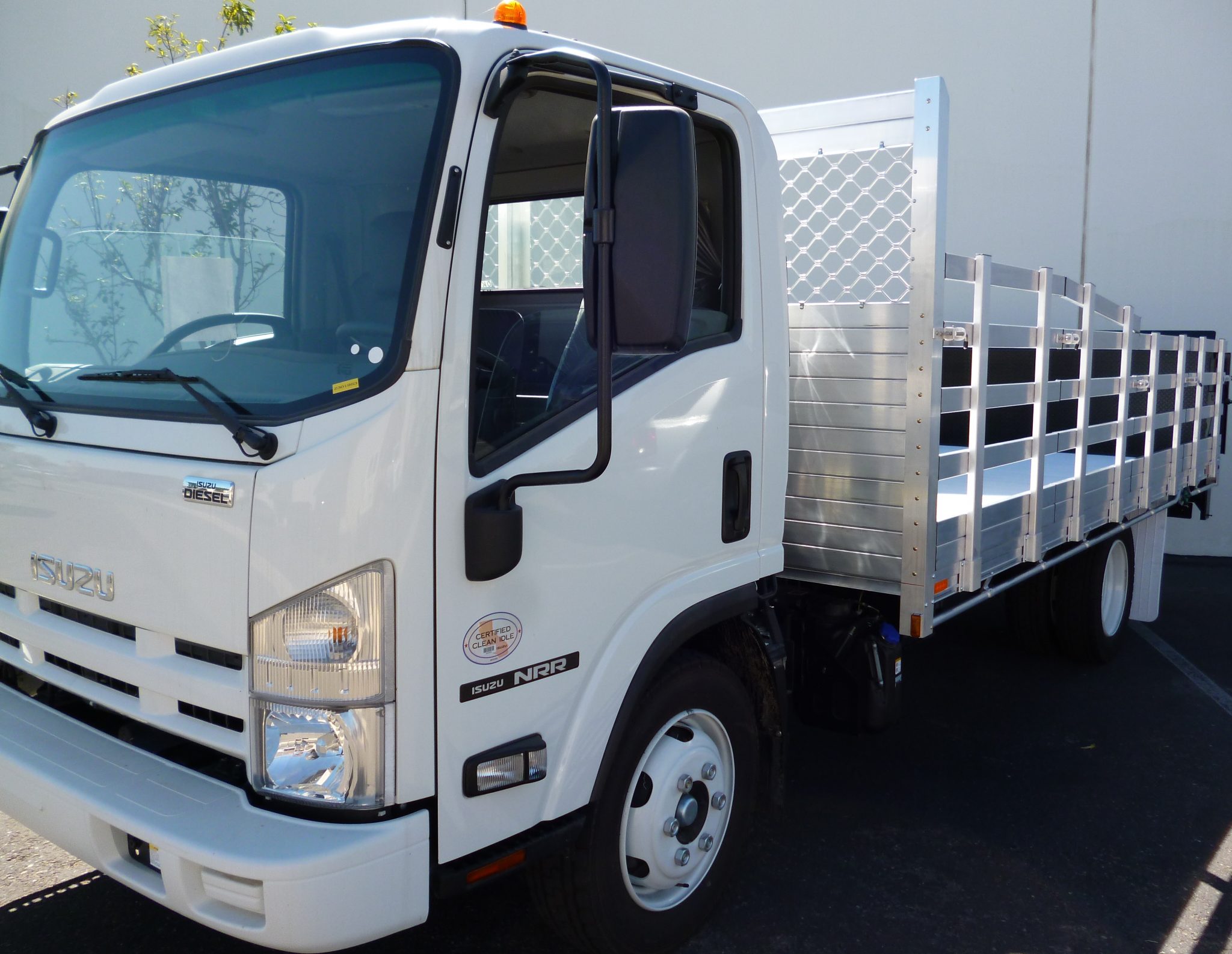 2014 Isuzu NPR with an 8' X 16' AlumBody aluminum stake bed with custom 38" and 30" lift out stakes and Tommygate lift gate