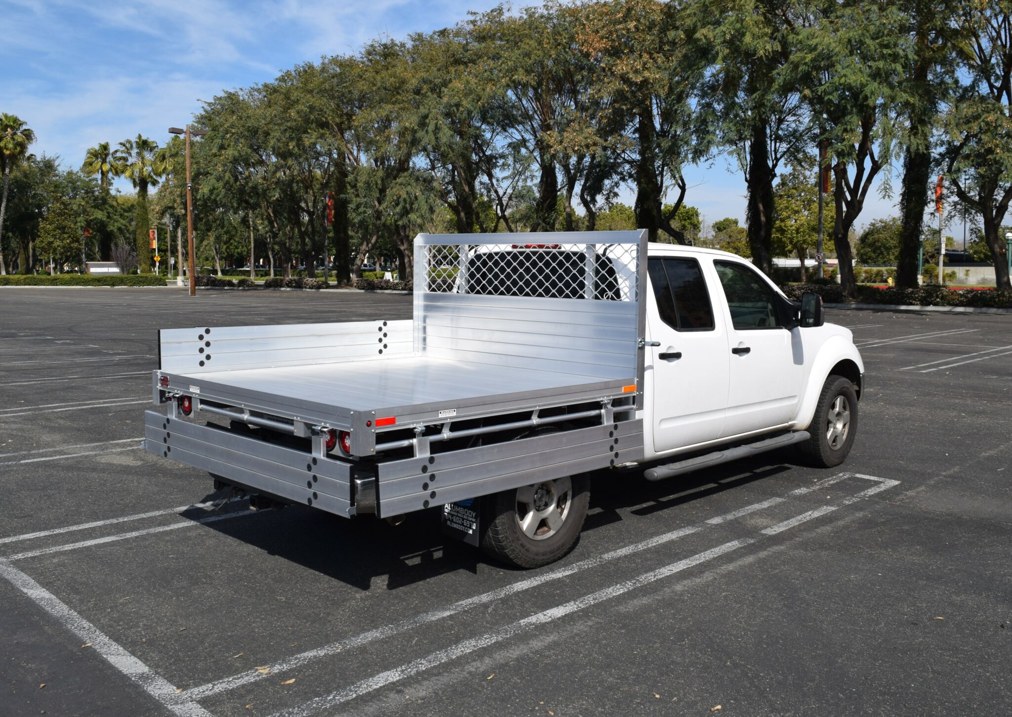 2008 Nissan Frontier with a 6'6''x6'6'', aluminum body with 9'' solid fold down gates, & rear rope rail, using the factory bumper