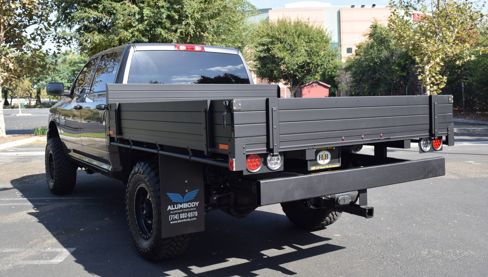 2018 Ram 2500 with a 7' X 8' AlumBody aluminum flat bed with 9" solid fold down gates with custom headboard powder coated matte black and dock bumper