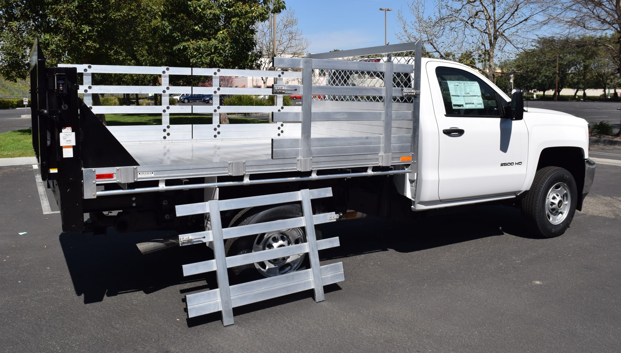 2016 Chevy Silverado 2500 with a 66" × 9' AlumBody aluminum stake bed with 38" lift-out stakes and Tommygate lift gate