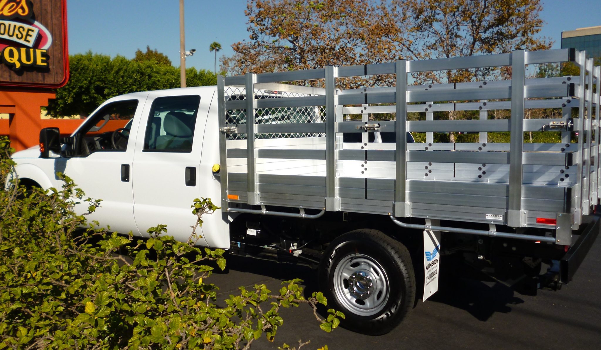 2015 Ford F350 with a 6'6" X 9' AlumBody aluminum stake bed with 38" lift out stakes and dock bumper