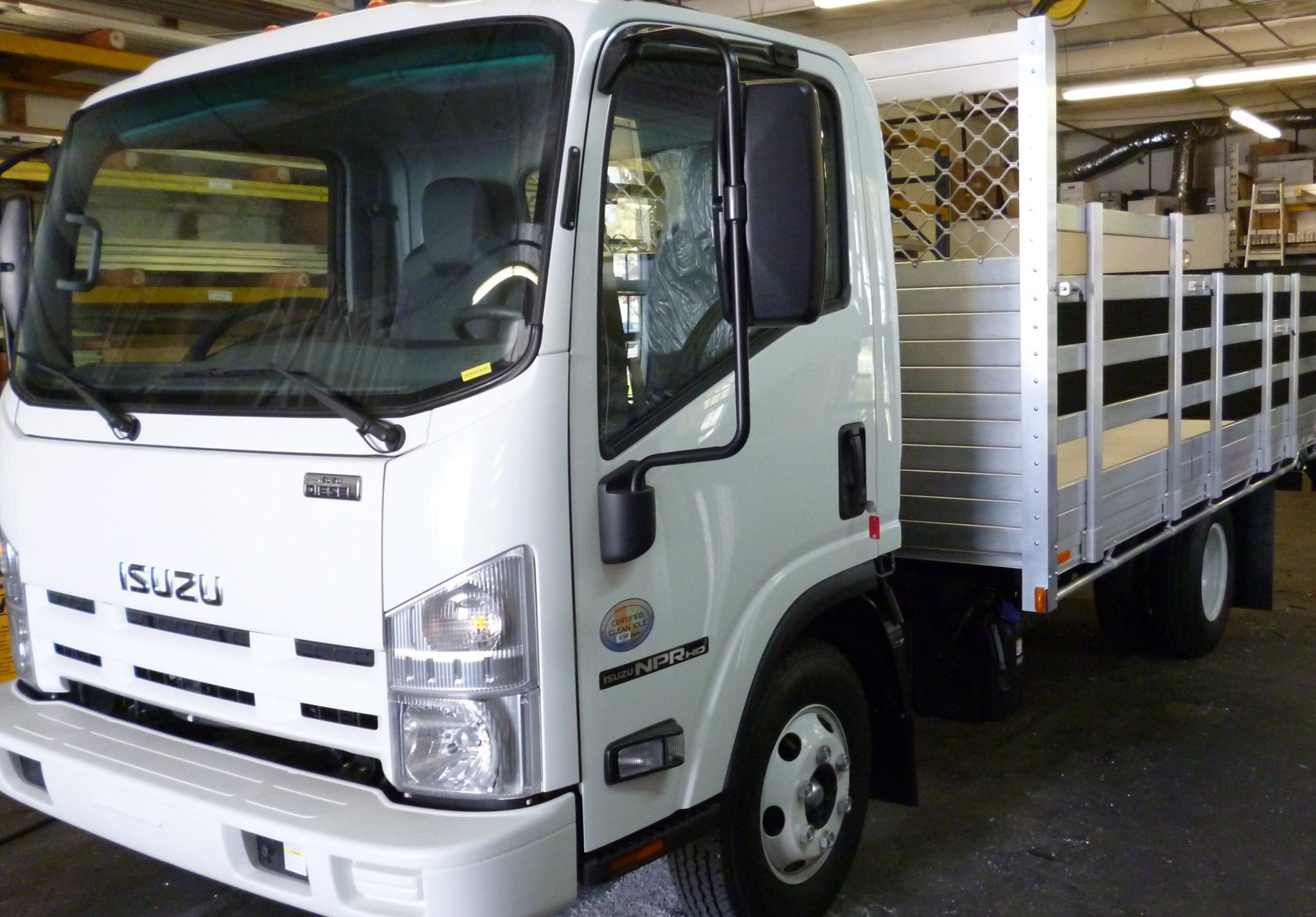 2015 Isuzu NPR with an 8' X 14' AlumBody aluminum stake bed with 38" and 30" lift out stakes and Tommygate lift gate