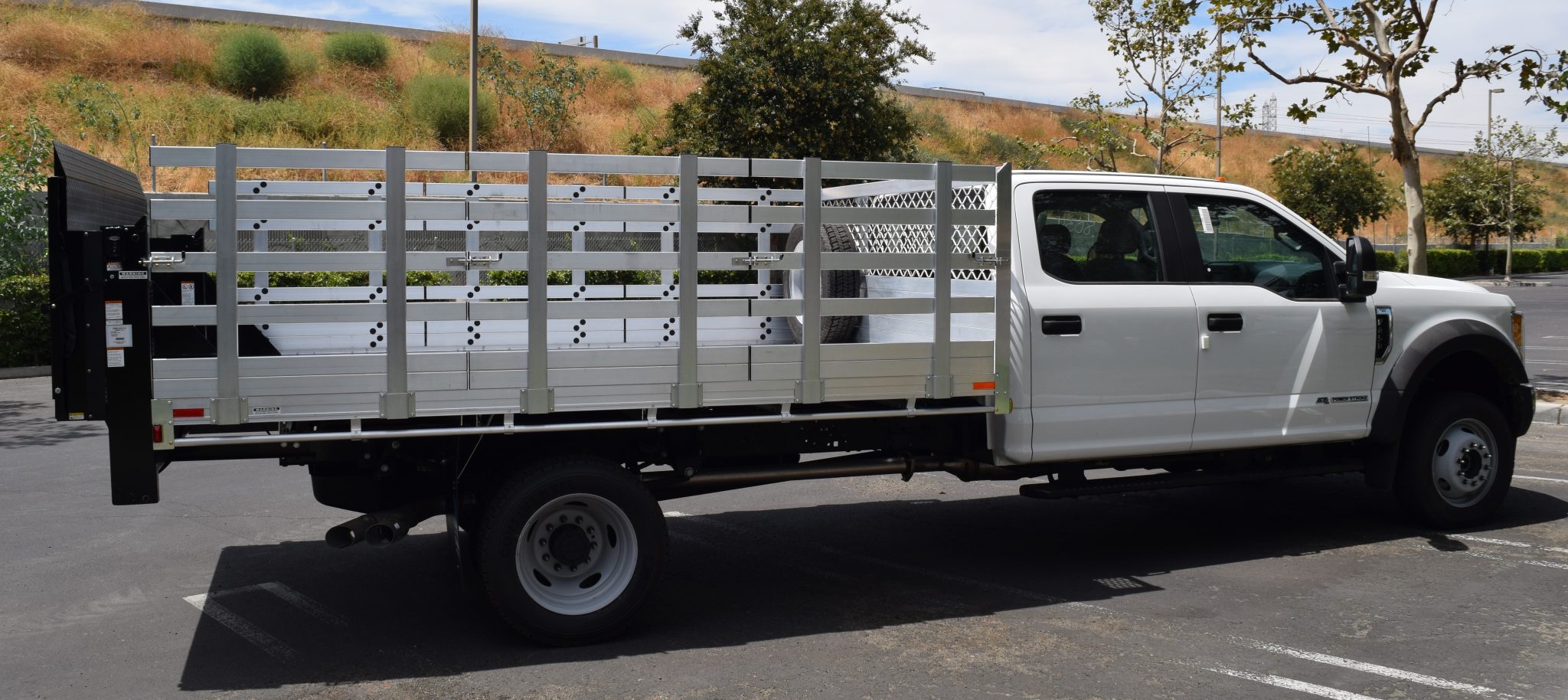 2017 Ford F450 Dual Rear Wheel with an 8' X 12 AlumBody aluminum stake bed 38" lift out stakes custom spare tire bracket and Tommygate lift gate