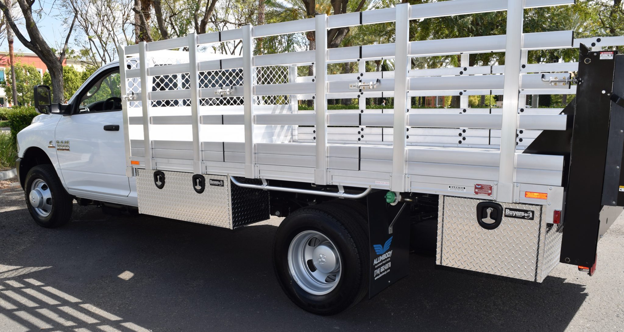 2016 Ram 3500 DRW with an 8' X 12' AlumBody aluminum stake bed with 38" lift out stakes, 4 underbody tool boxes 18" X 18" X 24" 18" X 18" X 36", and Tommygate lift gate