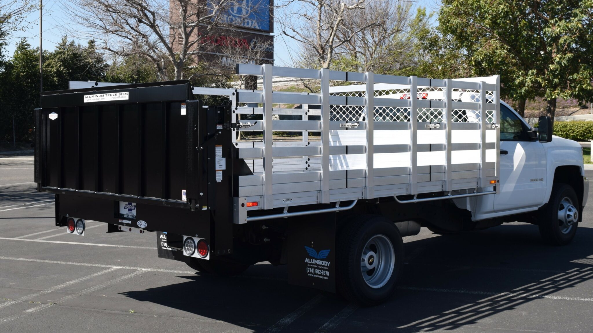2019 Chevy Silverado 3500 8×12 aluminum stake bed with a Tommy lift gate in the rear and 38" lift-out sides