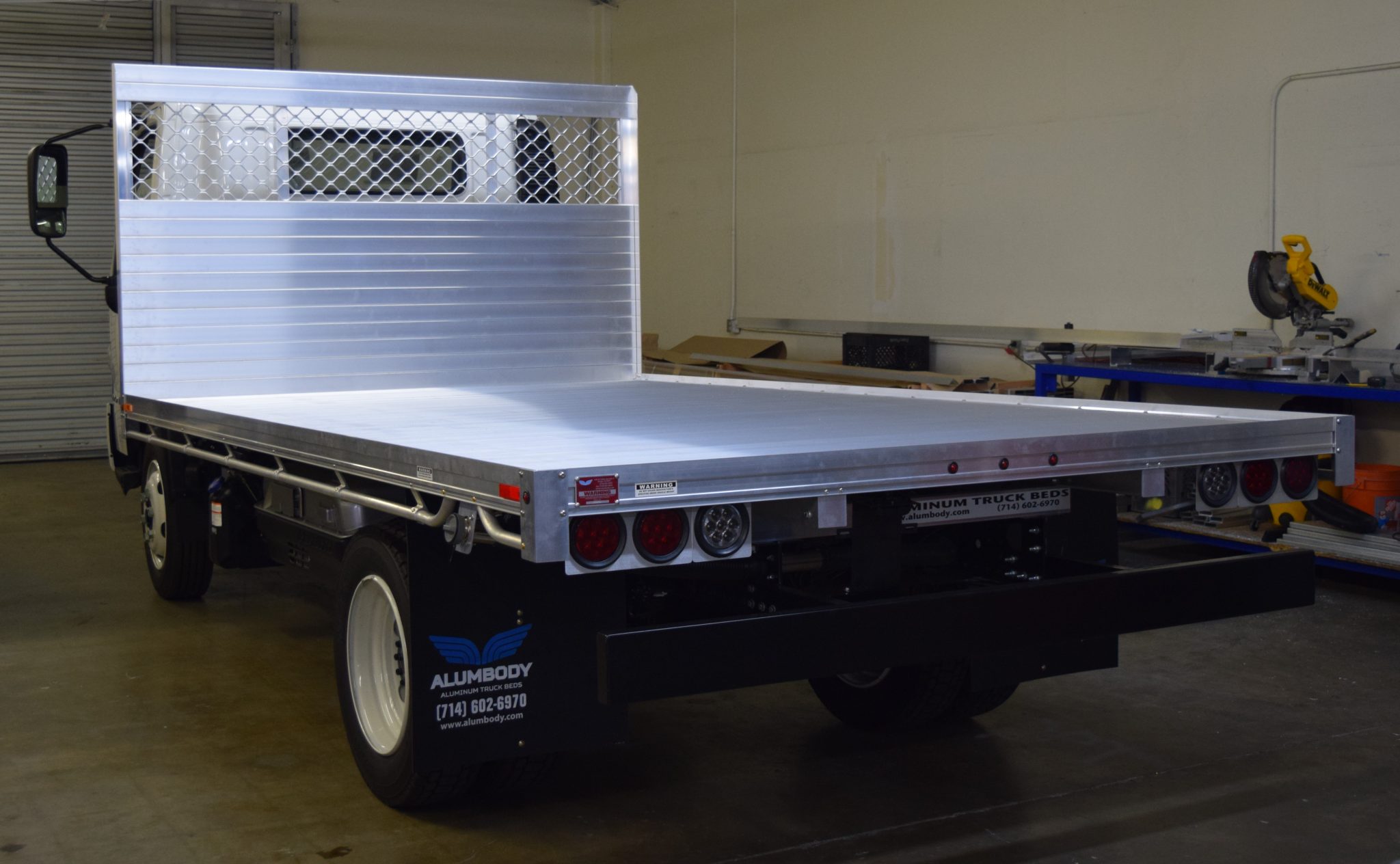 2019 Hino 195h with an 8' X 14' AlumBody aluminum flat bed with a heavy duty headboard constructed with stainless steel hardware and a dock bumper rear