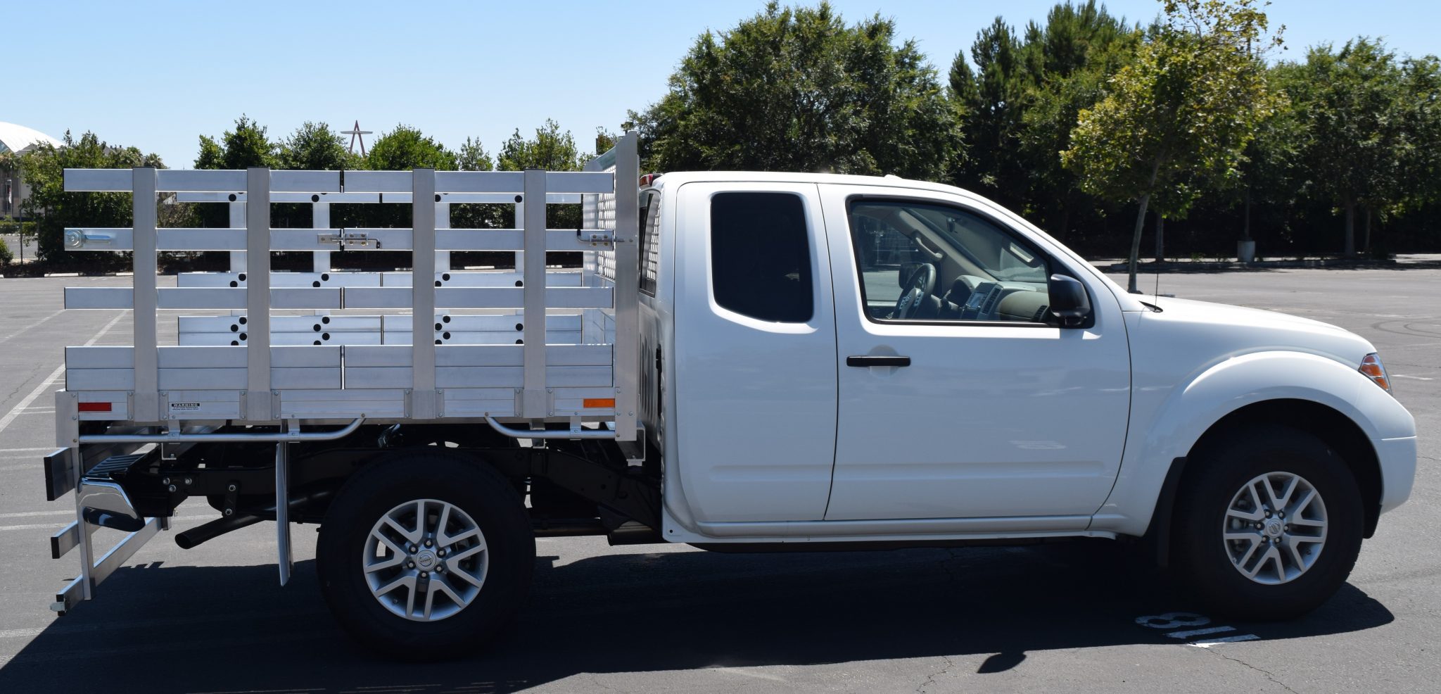 2017 Nissan Frontier with a 6' X 6'6" AlumBody aluminum stake bed with 33" lift out stakes and 22" fold down rear gate using the factory bumper