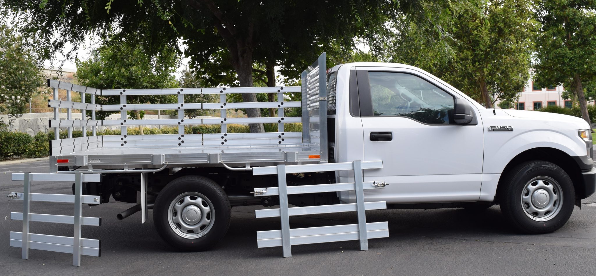 2015 Ford F150 with a 6'6" X 9' AlumBody aluminum stake bed with 30" lift out stakes using the factory bumper
