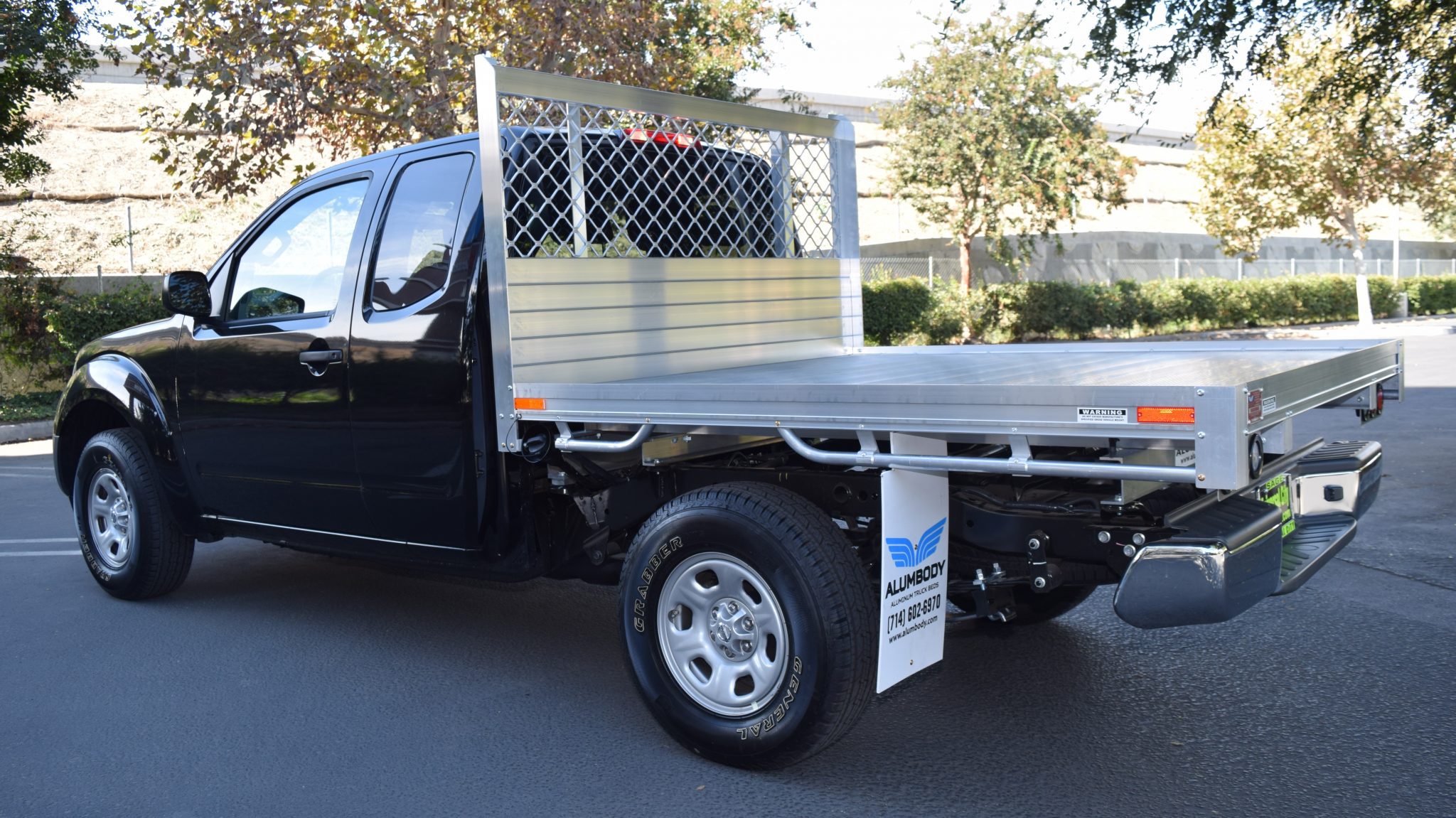 2016 Nissan Frontier with a 6' X 6'6" AlumBody aluminum flat bed using the factory bumper