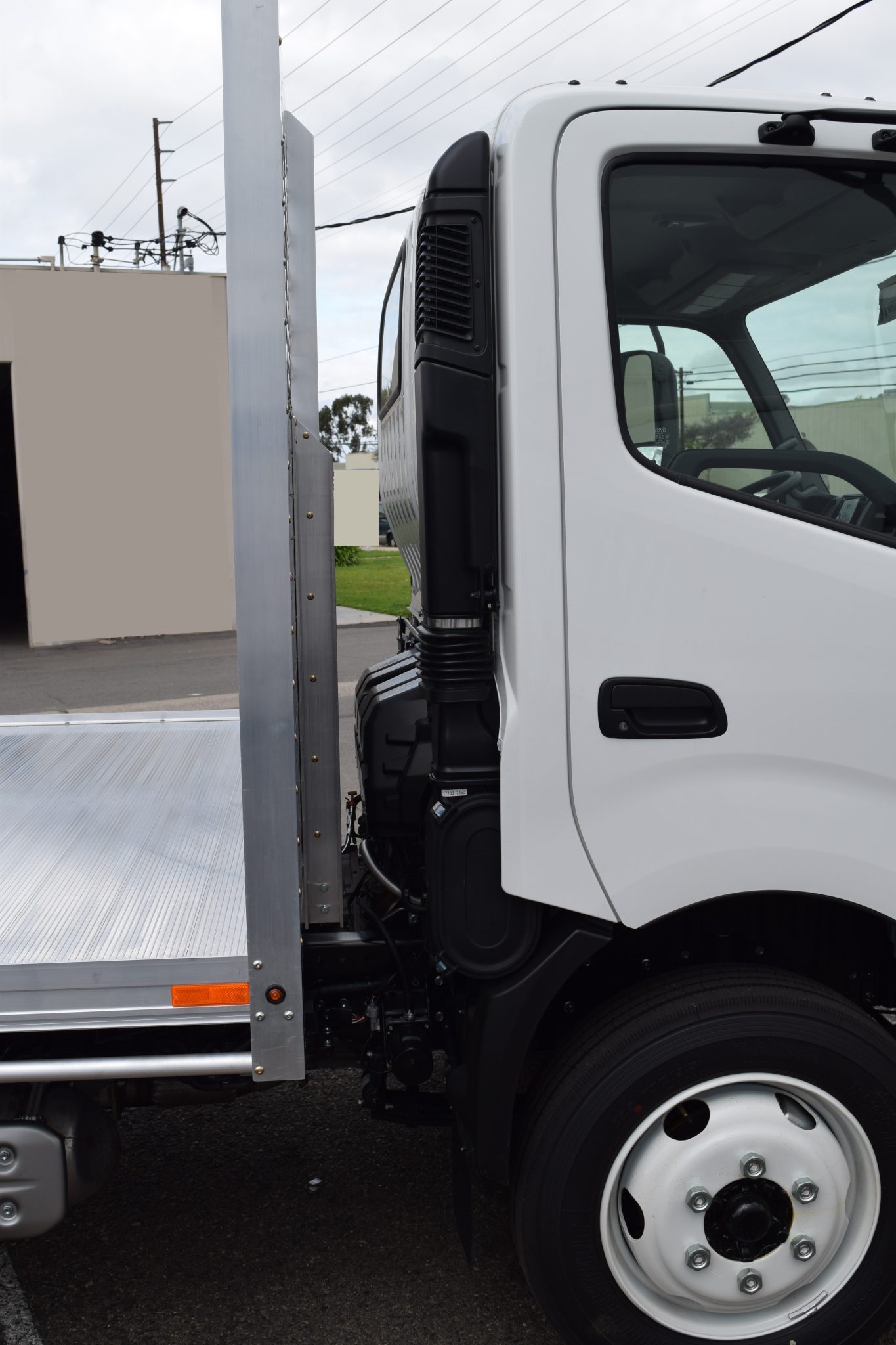 2019 Hino 195h with an 8' X 14' AlumBody aluminum flat bed with a heavy duty headboard constructed with stainless steel hardware and a dock bumper cab