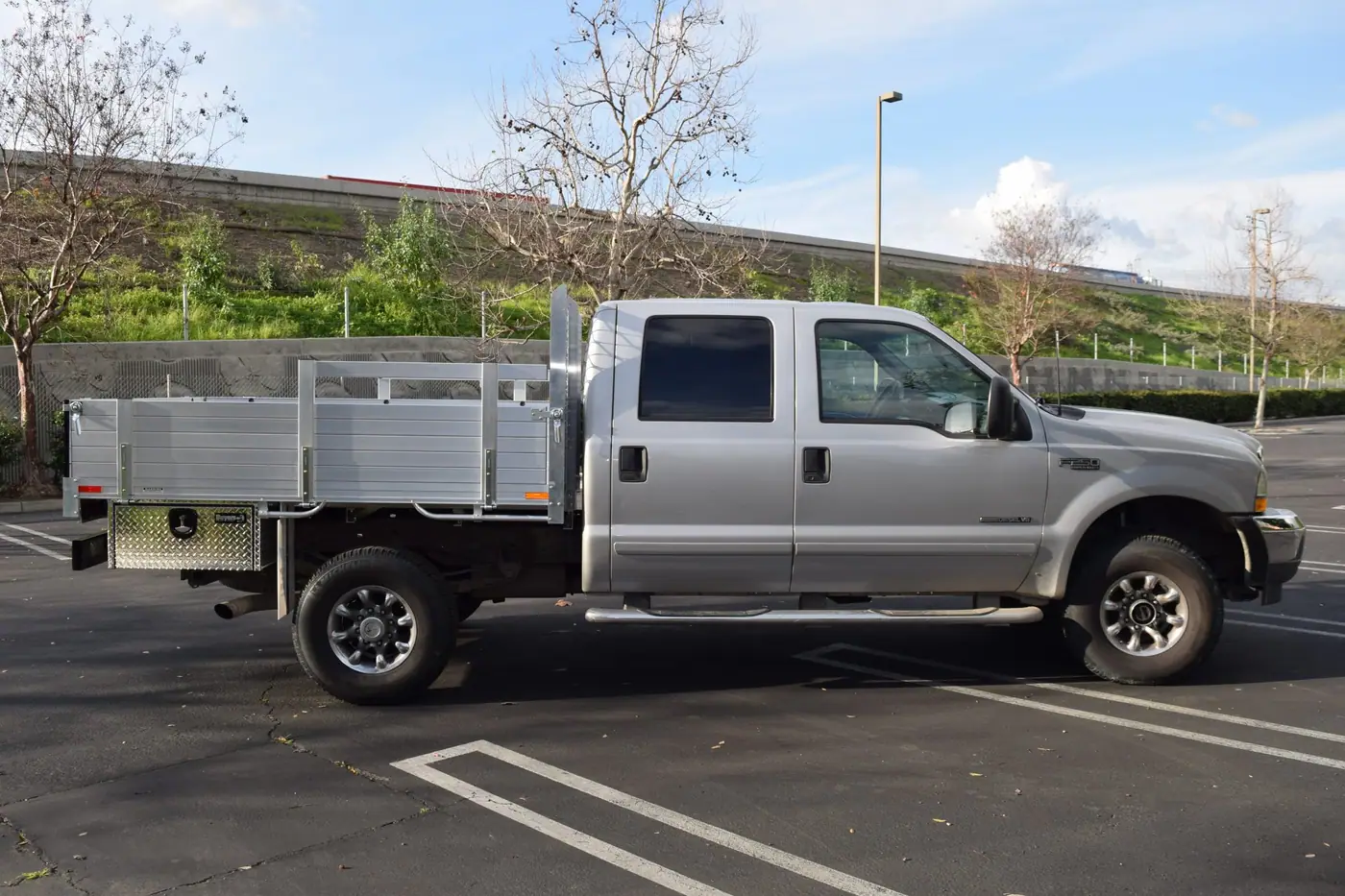 2003 Ford F250 with a 6'6" X 7'6" Alumbody aluminum flat bed with custom solid fold down gates 2 underbody tool boxes 14" X 12" X 30" and dock bumper