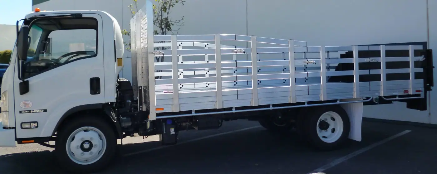 2014 Isuzu NPR with an 8' × 16' Alumbody aluminum stake bed with custom 38" and 30" lift-out stakes and Tommygate lift gate