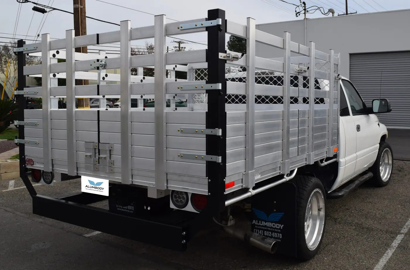 1999 Ram 1500 with a 6'6" X 8' Alumbody aluminum stake bed with custom 38" lift out stake sides and barn doors in the rear and dock bumper