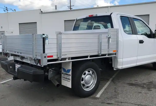 2018 Ford F150 with an 81" × 7' Alumbody aluminum pool truck bed with 9" solid fold-down gates using stainless steel hardware and the factory bumper