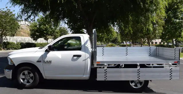 2014 Ram 1500 with a 6'6" X 9' Alumbody aluminum flat bed with 15" fold down gates using the factory bumper