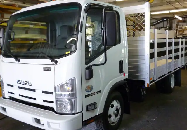 2015 Isuzu NPR with an 8' X 14' Alumbody aluminum stake bed with 38" and 30" lift out stakes and Tommygate lift gate