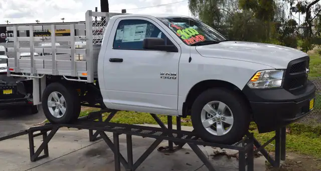 2015 Ram 1500 with a 6'6" X 7' Alumbody aluminum stake bed with 30" lift out stakes using the factory bumper