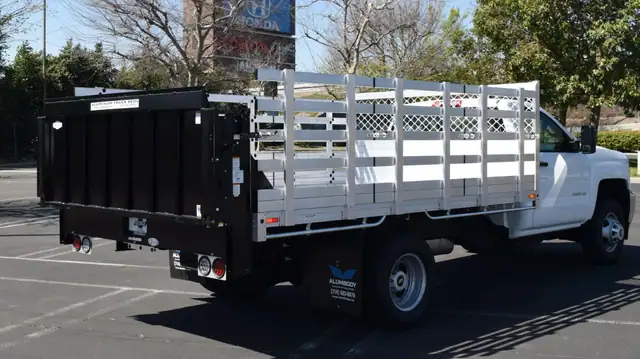 2019 Chevy Silverado 3500 8×12 aluminum stake bed with a Tommy lift gate in the rear and 38" lift-out sides
