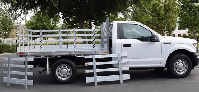 2015 Ford F-150 with a 6'6" × 9' Alumbody aluminum stake bed with 30" lift out stakes using the factory bumper