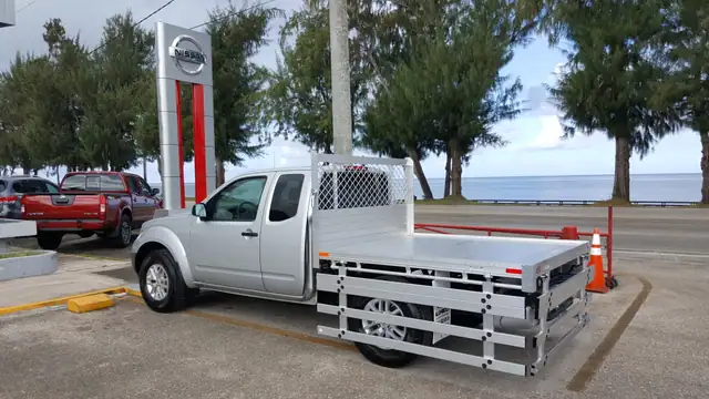 2017 Nissan Frontier with a 6' X 6'6" Alumbody aluminum flat bed with 22" fold down gates using the factory bumper