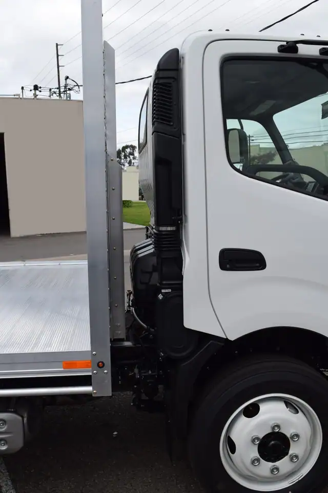 2019 Hino 195h with an 8' X 14' Alumbody aluminum flat bed with a heavy duty headboard constructed with stainless steel hardware and a dock bumper cab